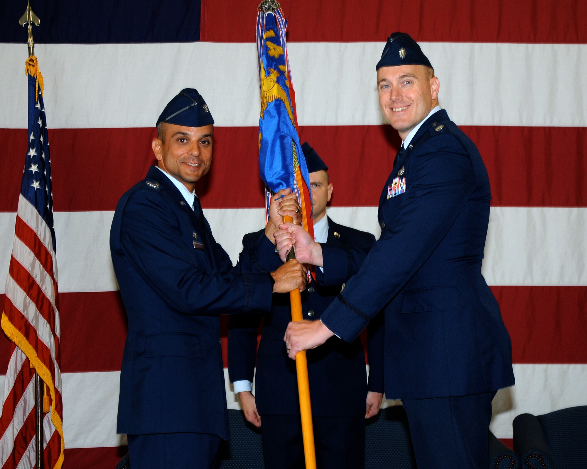 Col. Anthony Sansano, 14th Mission Support Group Commander, passes the 14th Civil Engineer Squadron guidon to Lt. Col. David Jokinen, the new 14th CES Commander, during a change of command ceremony June 28 at Columbus Air Force Base, Mississippi. (U.S. Air Force photo/Sharon Ybarra)