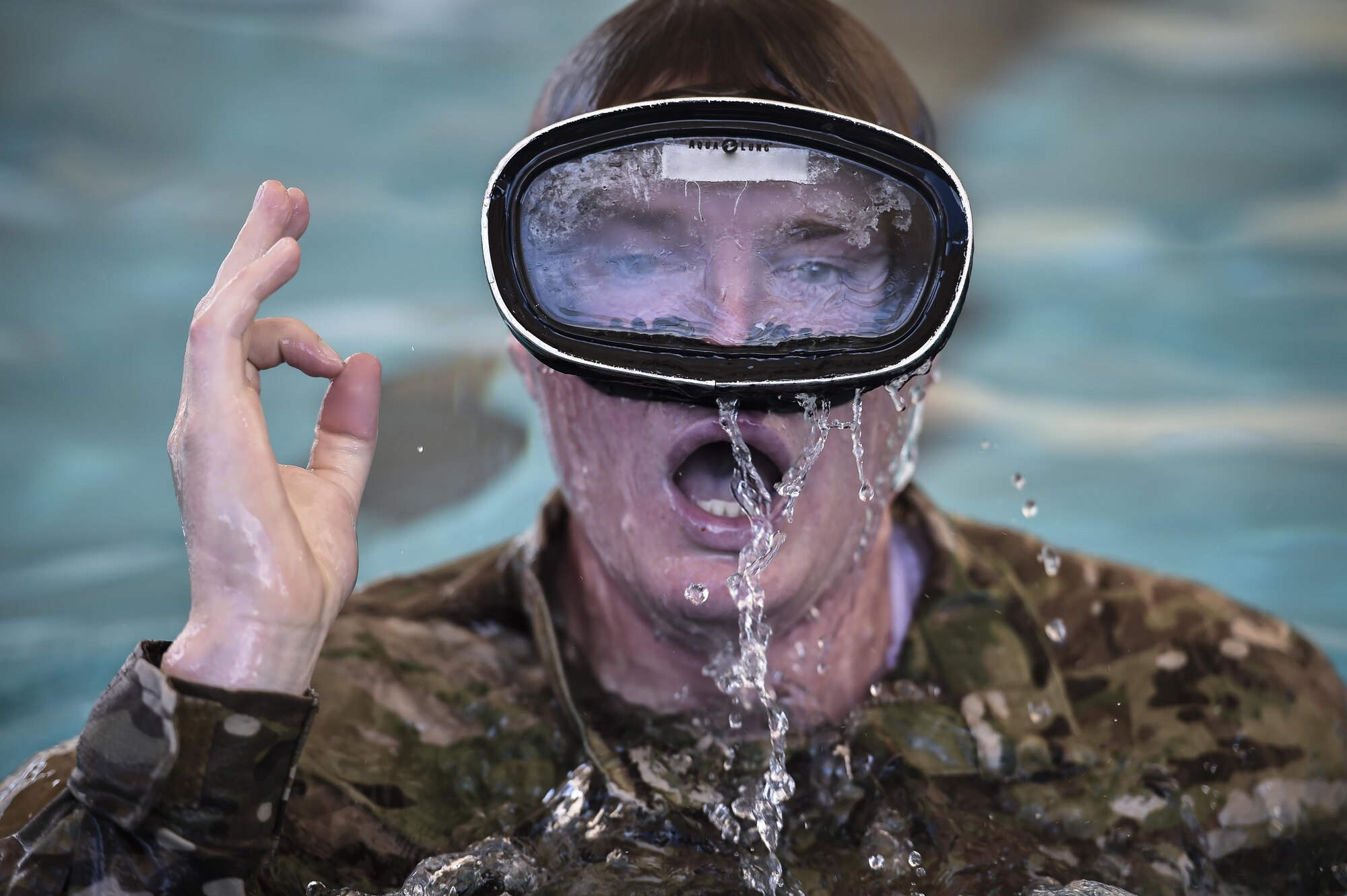 A Special Tactics Training Squadron student notifies the diving supervisor of his wellbeing during a pre-scuba class at Hurlburt Field, Fla., June 29, 2016. The training familiarizes trainees with the basics of water operations. The trainees perform tasks such as tying knots underwater, learning how to stay afloat without their arms and hands, and how to use snorkeling gear. Special Tactics students later apply this knowledge to combat dive training. This training also reproduces physiological effects similar those experienced on the battlefield, and thus builds the necessary mental resiliency for ground special operations force. (U.S. Air Force photo by Senior Airman Ryan Conroy) 