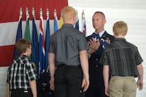 Chief Master Sgt. Geoff Weimer accepts the flag from his sons at his retirement ceremony at Minot Air Force Base, N.D., June 24, 2016. Weimer retired after 29 years of service and recently served as the command chief of the 5th Bomb Wing.(U.S. Air Force photo/Airman 1st Class Jessica Weissman)