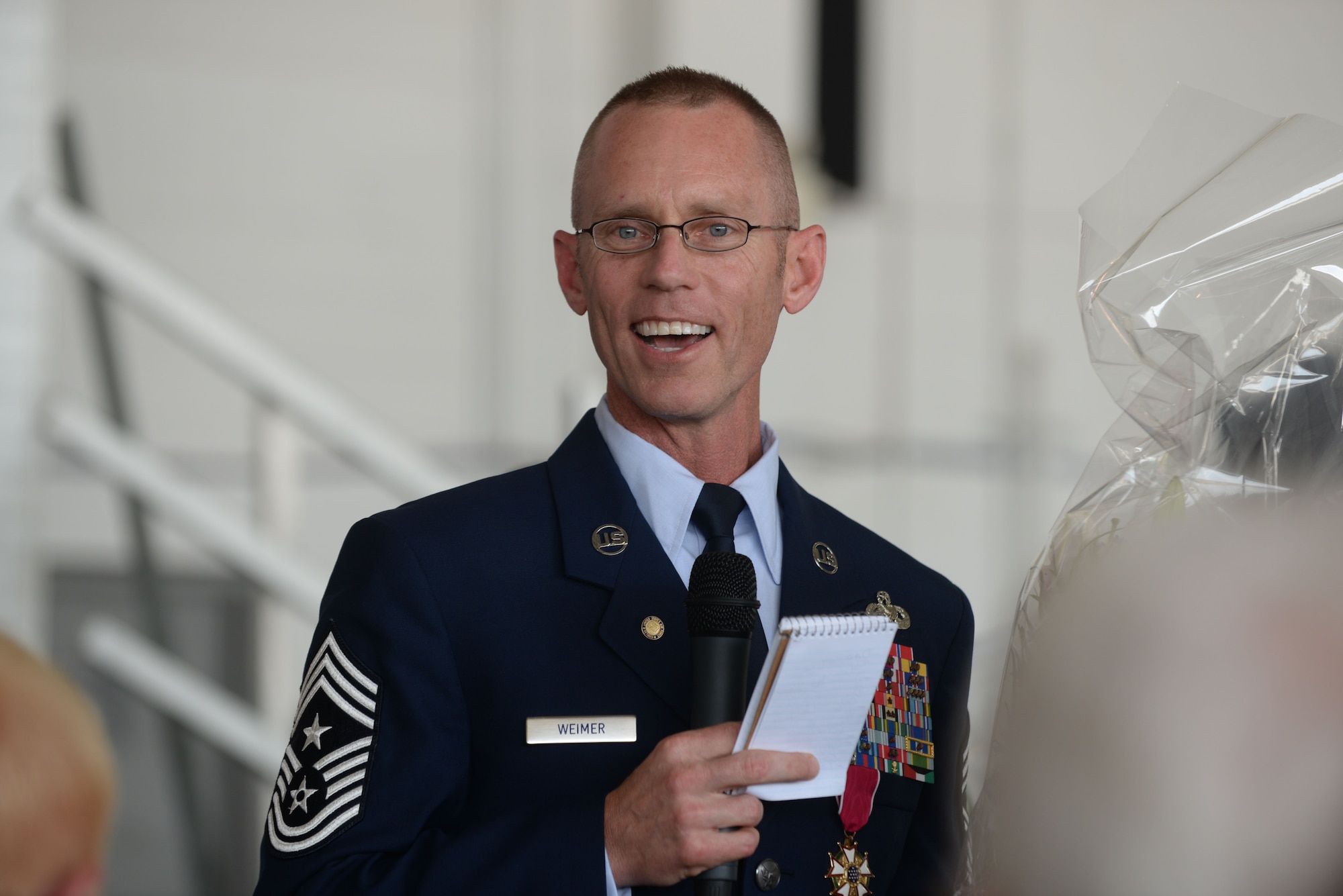 Chief Master Sgt. Geoff Weimer smiles at the crowd during his retirement ceremony at Minot Air Force Base, N.D., June 24, 2016. Weimer retired after 29 years of service and recently served as the command chief of the 5th Bomb Wing. (U.S. Air Force photo/Airman 1st Class Jessica Weissman)