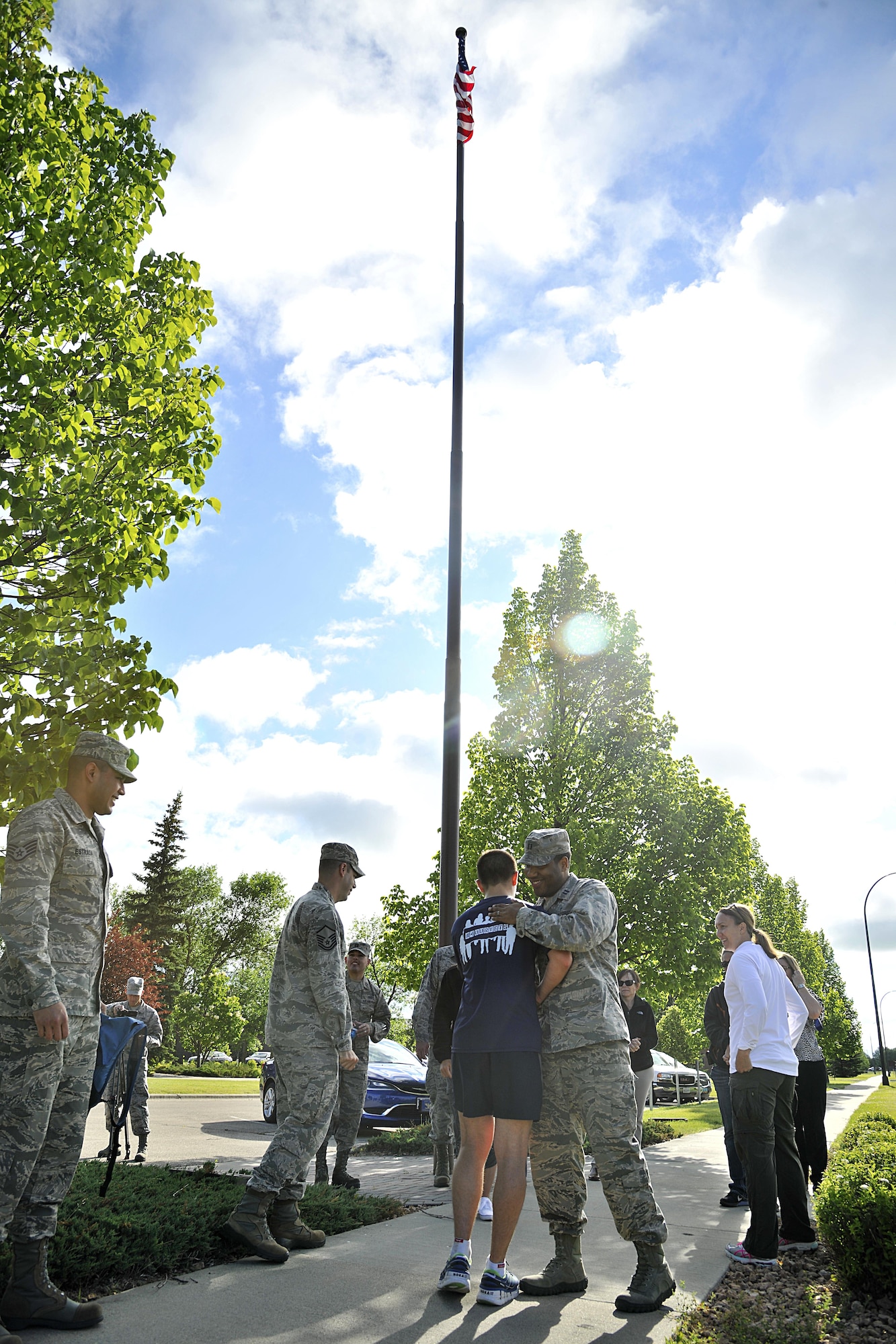 Staff Sgt. Brendan Brustad, 319th Air Base Wing assistant to the wing executive officer, is congratulated by members of the Warriors of the North in front of the wing building where he finished his 694 mile run as part of a month-long run for post-traumatic stress disorder awareness, June 30, 2016, on Grand Forks Air Force Base, N.D. The purpose of the run was to bring greater awareness to the veteran population and some of the struggles they endure. (U.S. Air Force photo by Senior Airman Xavier Navarro/Released)