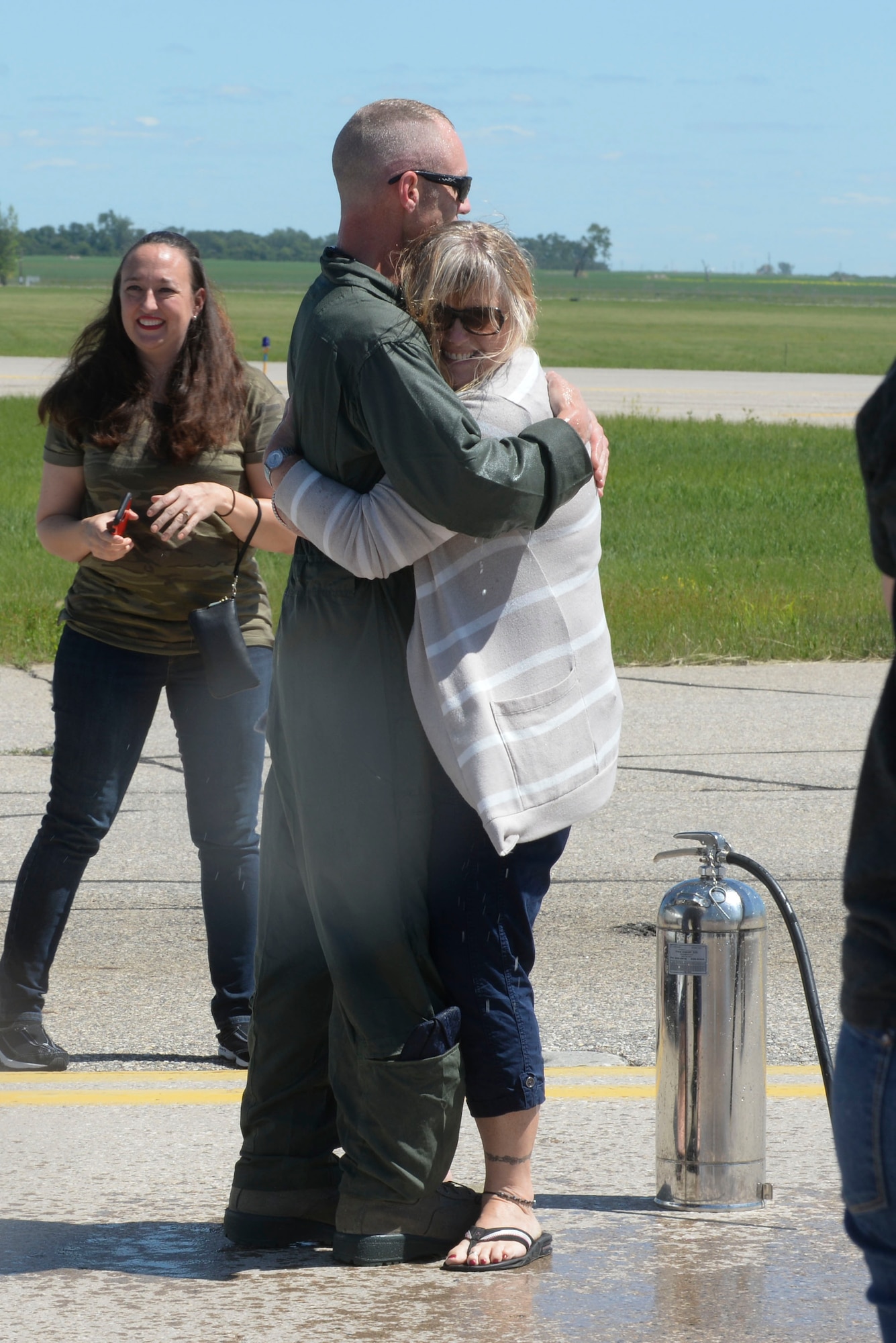 Chief Master Sgt. Geoff Weimer hugs his wife LeAnne after celebration of his “fini-flight” at Minot Air Force Base, N.D., June 23, 2016. The “fini-flight” is the final flight taken by an aircrew member at his current assignment. (U.S. Air Force photo/Airman 1st Class Jessica Weissman)