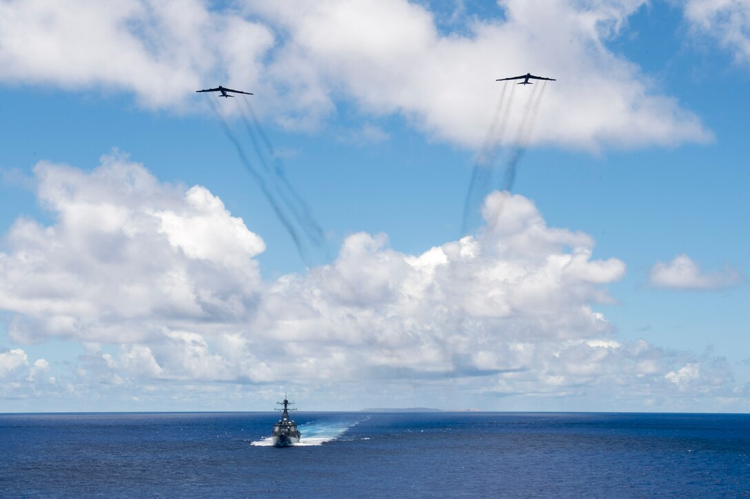 The guided-missile destroyer USS Spruance steams in the Pacific Ocean while two B-52 Stratofortress bombers, assigned to the 69th Expeditionary Bomb Squadron, fly overhead following a joint service targeting and bombing exercise. Spruance, along with the guided-missile destroyers USS Momsen and USS Decatur and embarked helicopter detachments of Maritime Strike Squadron 49, are deployed in support of maritime security and stability in the Indo-Asia-Pacific region. (U.S. Navy photo/Mass Communication Specialist 2nd Class Will Gaskill) 