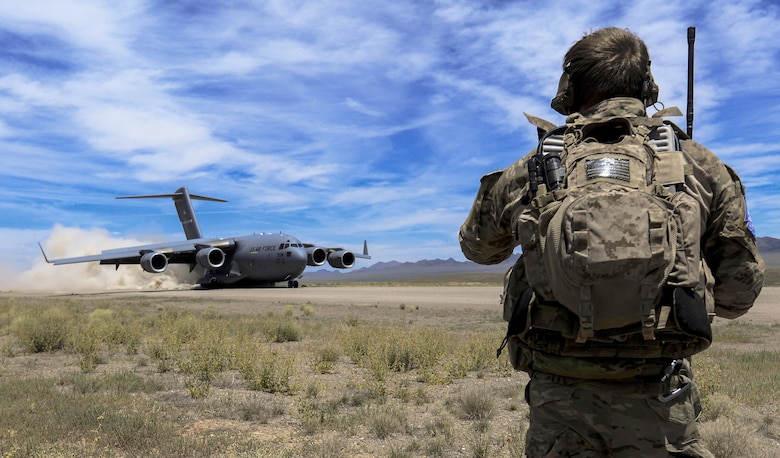 A combat controller watches as a C-17 Globemaster III, assigned to the 17th Weapons Squadron at Nellis Air Force Base, Nev., lands on an airstrip in the Nevada Test and Training Range during a joint forcible entry exercise June 16, 2016. The exercise demonstrated the Air Force’s ability to tactically deliver and recover combat forces via air drops and combat landings in a contested environment. (U.S. Air Force photo/Airman 1st Class Kevin Tanenbaum)