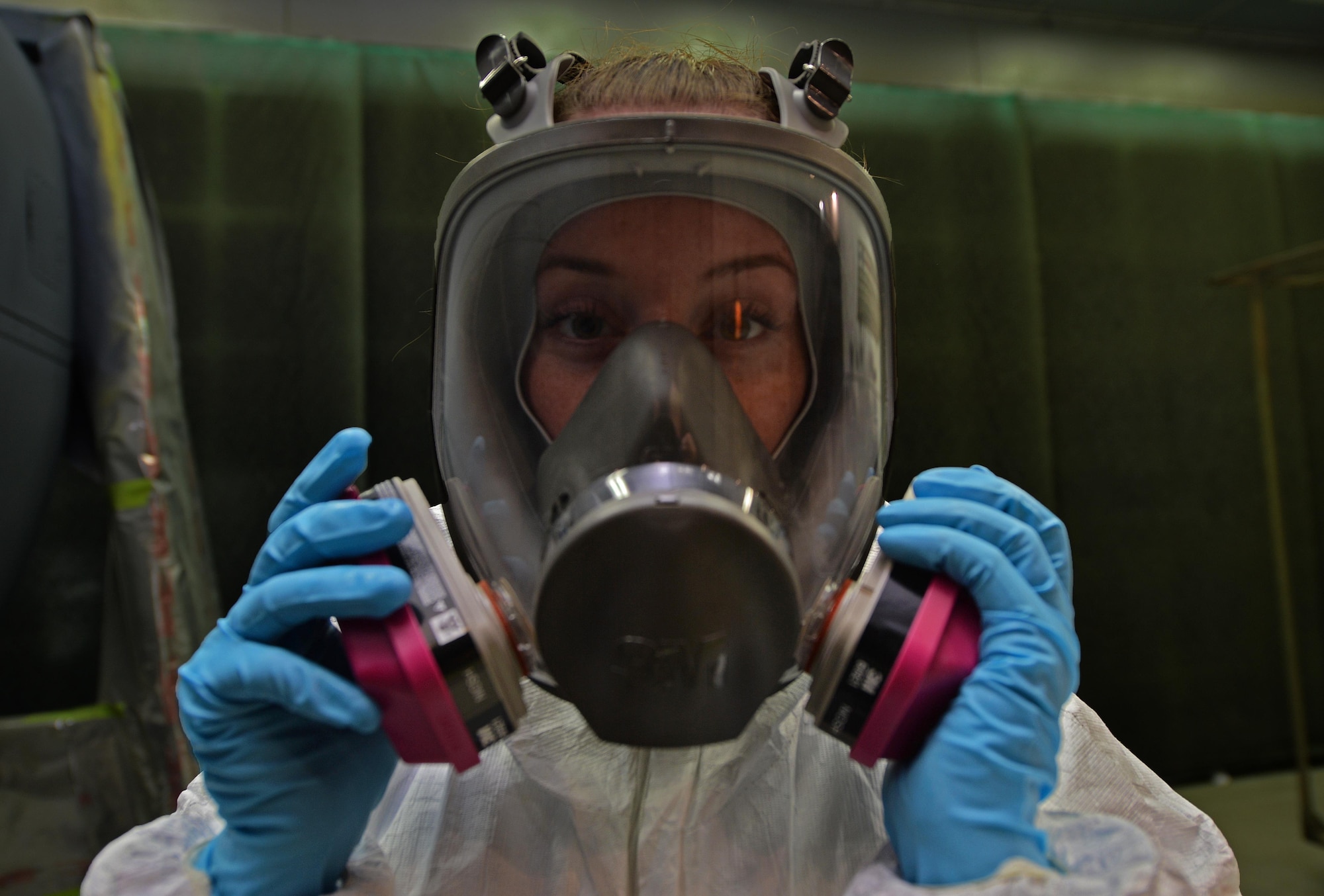 Airman 1st Class Taylor Hill, an aircraft structural maintenance journeyman with the 1st Special Operations Maintenance Squadron, puts on a full-face respirator mask before painting an engine kit at Hurlburt Field, Fla., June 29, 2016. Corrosion specialist wear these masks to protect themselves from the toxic fumes and residue used in materials for corrosion prevention such as paint. (U.S. Air Force photo by Senior Airman Andrea Posey)