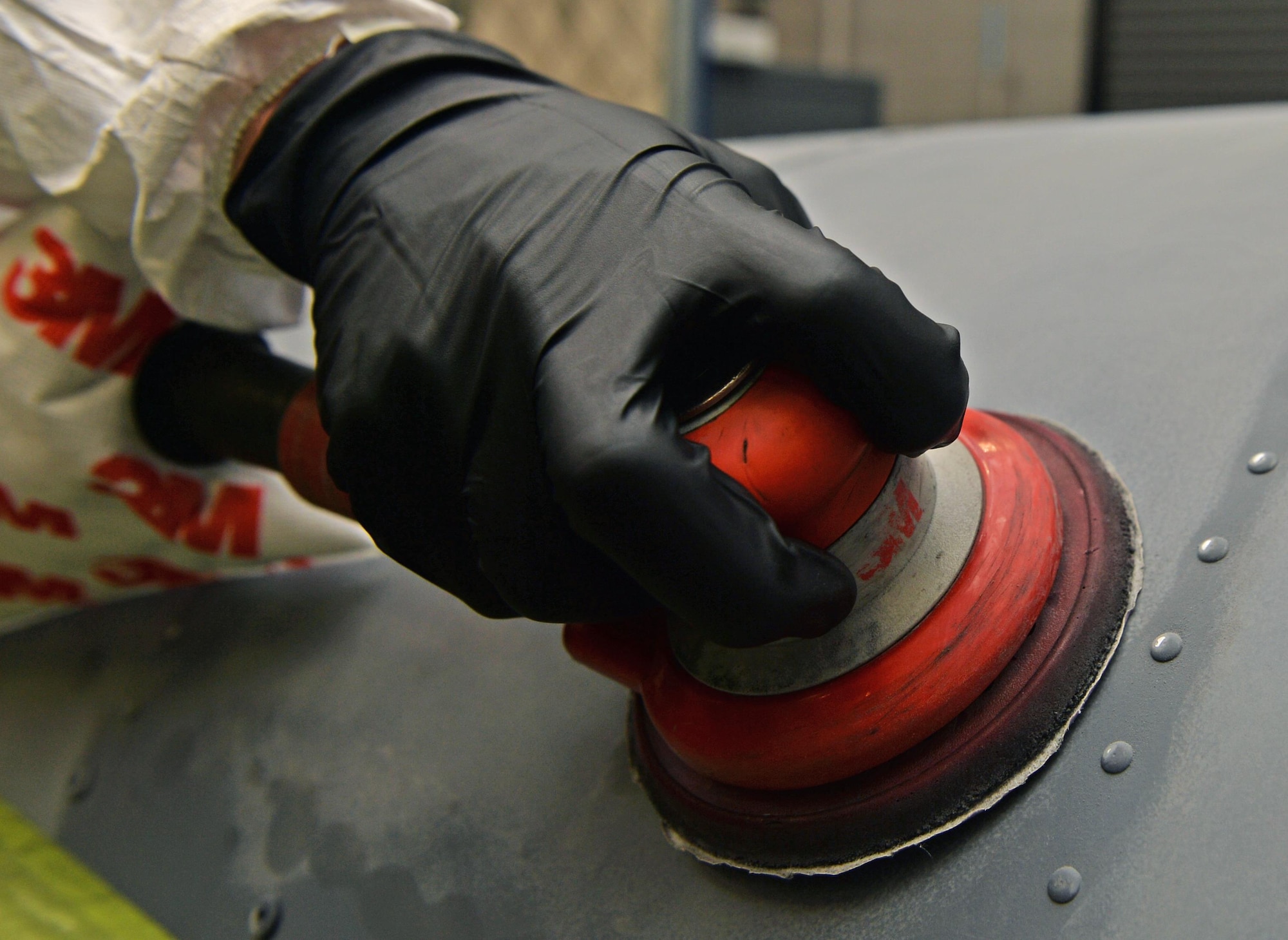 Airman Jay Adams, an aircraft structural maintenance journeyman with the 1st Special Operations Maintenance Squadron, sands an engine cowling at Hurlburt Field, Fla., June 29, 2016. During sanding, the old layer of paint is removed to create a better adhesive surface for the corrosion-preventing paint. (U.S. Air Force photo by Senior Airman Andrea Posey)