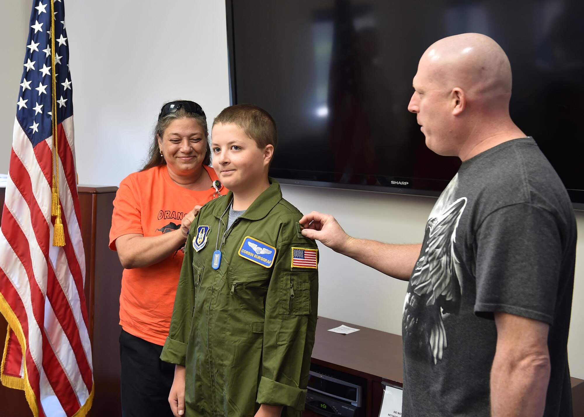 George Burggraf (right), father of Corbin Burggraf (center), and Teresa Ruozza from Akron Children’s Hospital’s Center of Blood and Cancer, place rank insignias on Corbin’s shoulders after he was commissioned as an honorary 2nd Lt. by 910th Mission Support Group commander Col. Donald Wren here, June 29. Corbin was selected as the 910th Airlift Wing’s 63rd Pilot for a Day honoree and experienced a day of military themed events at YARS. The Pilot for a Day program welcomes children with life threatening or chronic illnesses to Youngstown Air Reserve Station for a day of fun military experiences. (U.S. Air Force photo/Eric White)