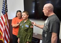 George Burggraf (right), father of Corbin Burggraf (center), and Teresa Ruozza from Akron Children’s Hospital’s Center of Blood and Cancer, place rank insignias on Corbin’s shoulders after he was commissioned as an honorary 2nd Lt. by 910th Mission Support Group commander Col. Donald Wren here, June 29. Corbin was selected as the 910th Airlift Wing’s 63rd Pilot for a Day honoree and experienced a day of military themed events at YARS. The Pilot for a Day program welcomes children with life threatening or chronic illnesses to Youngstown Air Reserve Station for a day of fun military experiences. (U.S. Air Force photo/Eric White)