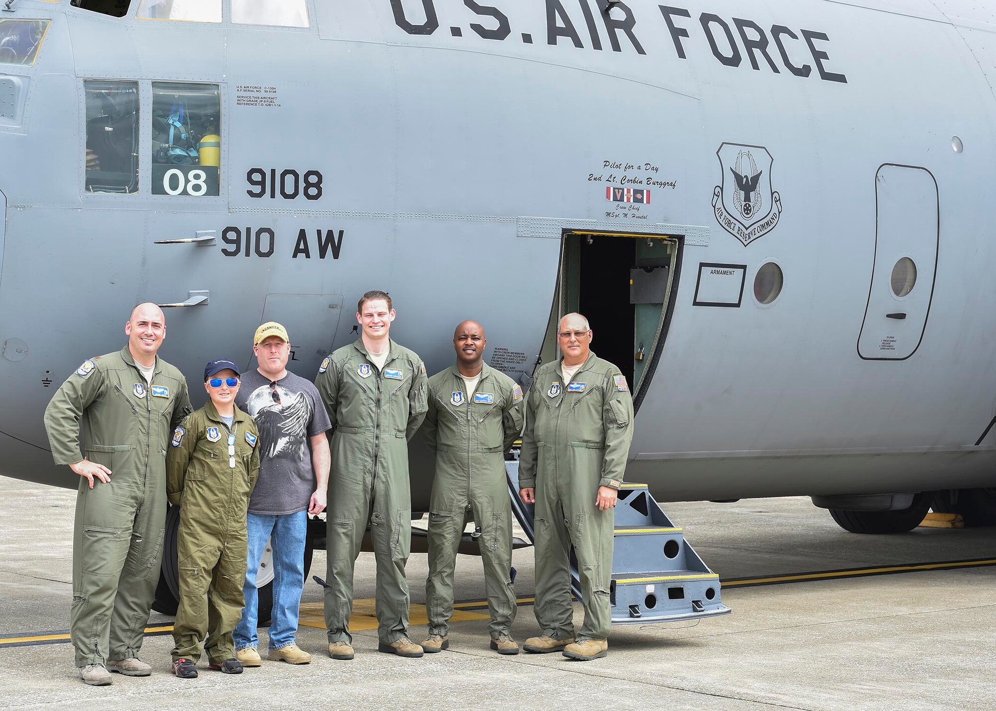 Honorary 2nd Lt. Corbin Burggraf (second from left), the 910th Airlift Wing’s 63rd Pilot for a Day, and his dad George pose for a photo with aircrew members by the crew door of a C-130H Hercules aircraft here, June 29. Corbin and George were taken on a runway taxi as part of the Pilot for a Day program by aircrew members (from left to right) pilots Maj. Ryan Grey and Lt. Devin Keigley, and loadmasters Master Sgt. Lafayette Smith and Master Sgt. Vincent Bartlomain, all from the 757th Airlift Squadron here. The Pilot for a Day program welcomes children with life threatening or chronic illnesses to Youngstown Air Reserve Station for a day of fun military experiences. (U.S. Air Force photo/Eric White)