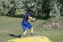 Noah Edgerton, a member of the youth center at Minot Air Force Base, N.D., runs for cover during Paintball 101 June 17, 2016. This program was offered as part of the summer camps available by the youth center to teach basic knowledge of paintball. (U.S. Air Force photo/Airman 1st Class Jessica Weissman)