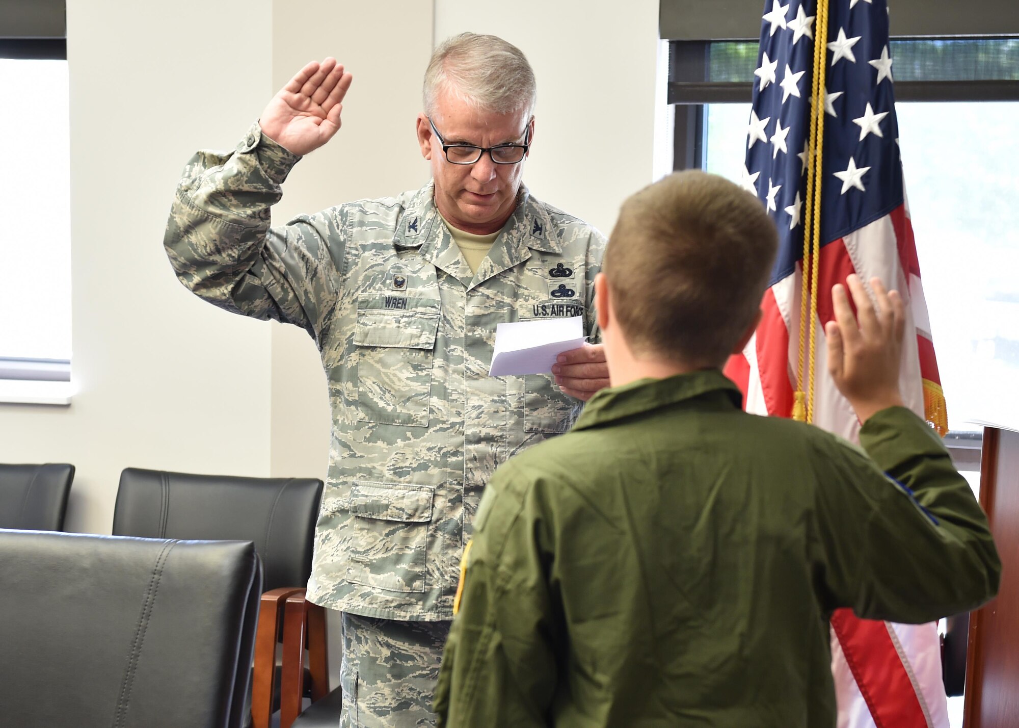 Col. Donald Wren, 910th Mission Support Group Commander, administers the commissioning oath to 14-year-old Corbin Burggraf, the 910th Airlift Wing’s 63rd Pilot for a Day honoree, making him an honorary 2nd Lt. here, June 29. Burggraf, who received treatment at Akron Children’s Hospital for leukemia, experienced a day of fun military themed activities here. The Pilot for a Day program welcomes children with life threatening or chronic illnesses to Youngstown Air Reserve Station for a day of fun military experiences. (U.S. Air Force photo/Eric White
