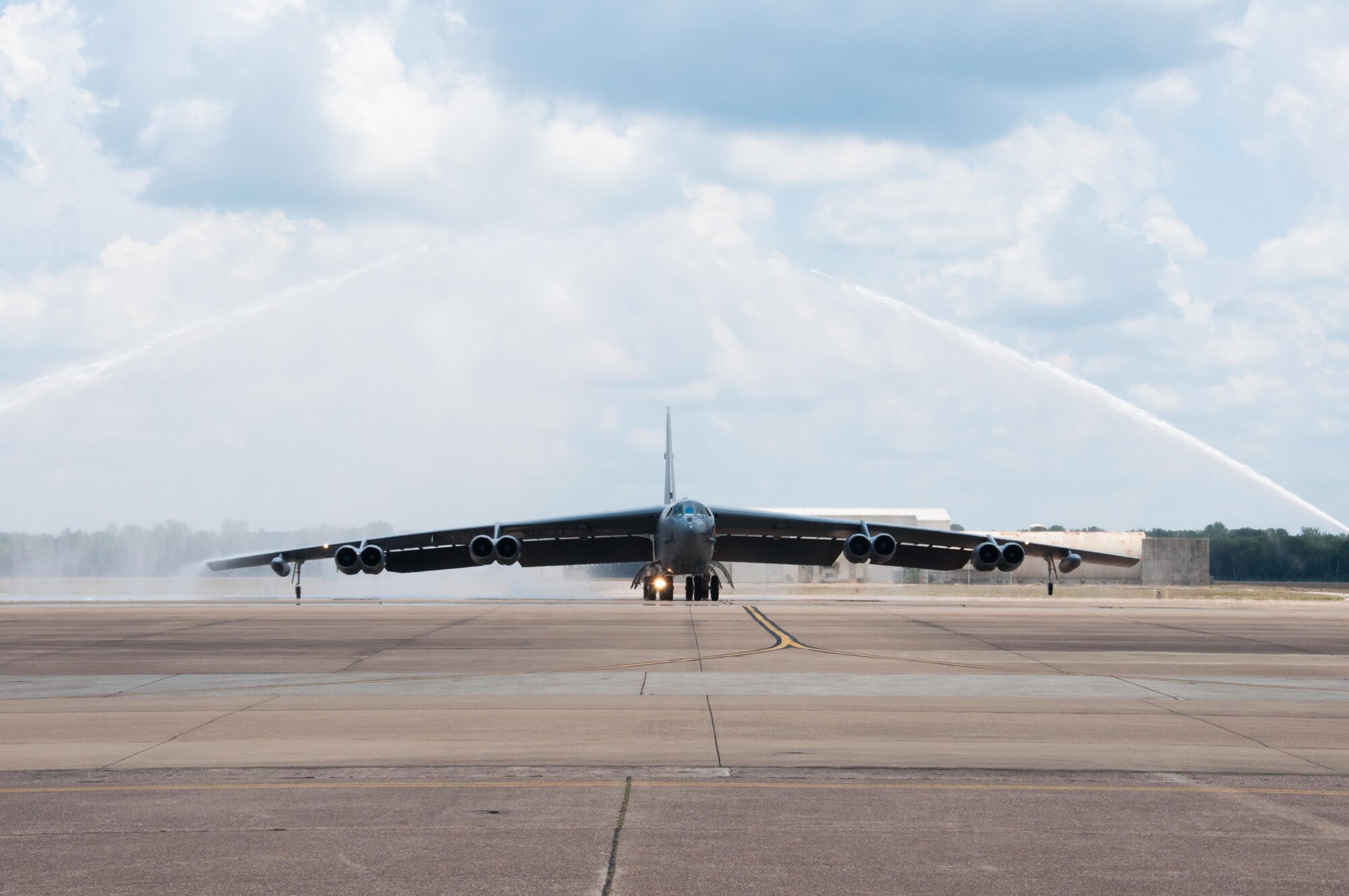 A B-52 Stratofortress assigned to the 307th Bomb Wing taxis under the spray from two fire trucks on Barksdale Air Force Base, La. on June 19, 2016. Aboard the bomber are three Airmen from the 93rd Bomb Squadron that have just completed their last mission in the B-52; Col. Robert VanHoy, Lt. Col. Christopher Talbot and Lt. Col. John Wells. (U.S. Air Force photo by Tech. Sgt. Cody Burt/Released)