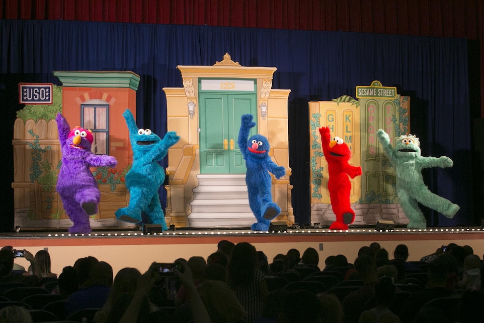 Sesame Street characters dance and sing during the USO Sesame Street Experience for Military Families held at the Sunset Cinema, aboard Marine Corps Air Ground Combat Center, Twentynine Palms, Calif., June 22, 2016. (Official Marine Corps photo by Cpl. Thomas Mudd/Released)