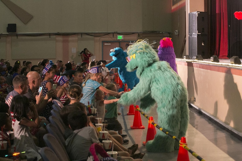 Sesame Street characters interact with children in the audience during the USO Sesame Street Experience for Military Families held at the Sunset Cinema, aboard Marine Corps Air Ground Combat Center, Twentynine Palms, Calif., June 22, 2016.(Official Marine Corps photo by Cpl. Thomas Mudd/Released)