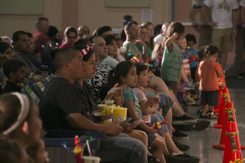 Combat Center families watch Sesame Street characters sing and dance during the USO Sesame Street Experience for Military Families held at the Sunset Cinema, aboard Marine Corps Air Ground Combat Center, Twentynine Palms, Calif., June 22, 2016. (Official Marine Corps photo by Cpl. Thomas Mudd/Released)