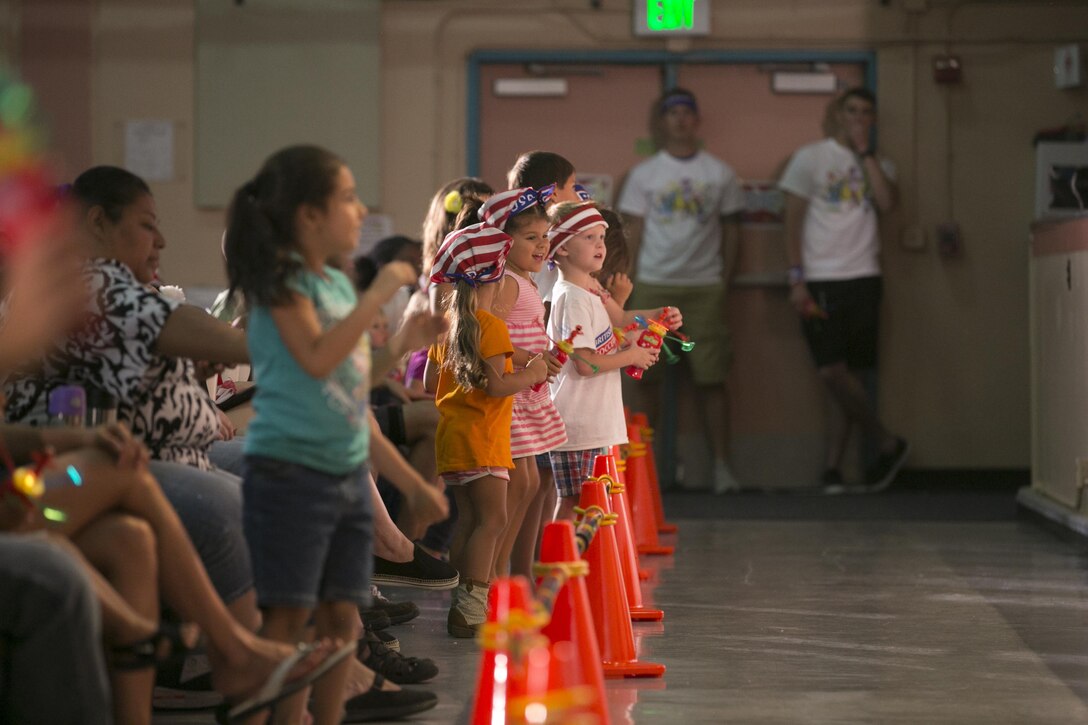 Combat Center children dance along with Sesame Street characters during the USO Sesame Street Experience for Military Families held at the Sunset Cinema, aboard Marine Corps Air Ground Combat Center, Twentynine Palms, Calif., June 22, 2016. (Official Marine Corps photo by Cpl. Thomas Mudd/Released)