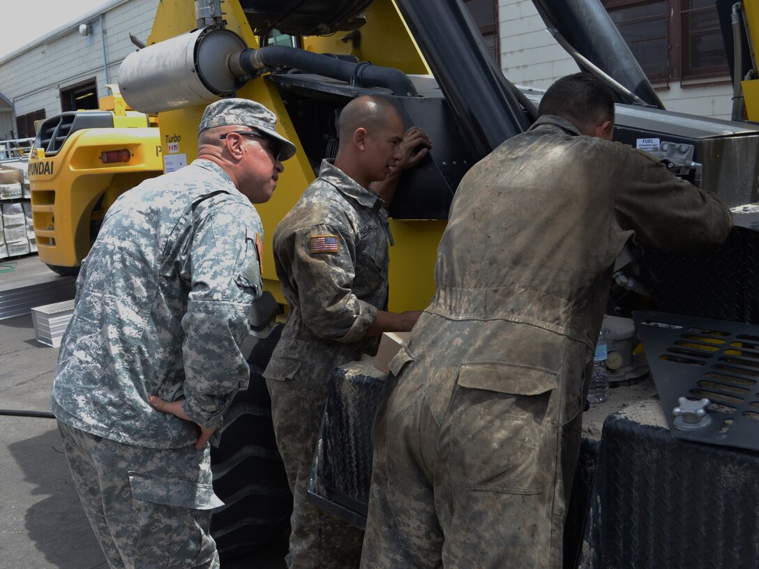 Command Sgt. Maj. Mario Canizales, 650th Regional Support Group command sergeant major, watches wheeled vehicle mechanics change the oil in a forklift at the Sierra Army Depot June 10, during an annual training event. The Sierra Army Depot is an ammunition and surplus storage terminal, located near the unincorporated community of Herlong, California.