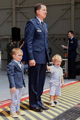 Col. Christopher Sage, 4th Fighter Wing commander, stands with two of his children during a flagship renaming ceremony, June 30, 2016, at Seymour Johnson Air force Base, North Carolina. Sage assumed command of the 4th Fighter Wing from Col. Mark Slocum. (U.S. Air Force photo/Airman 1st Class Ashley Williamson)