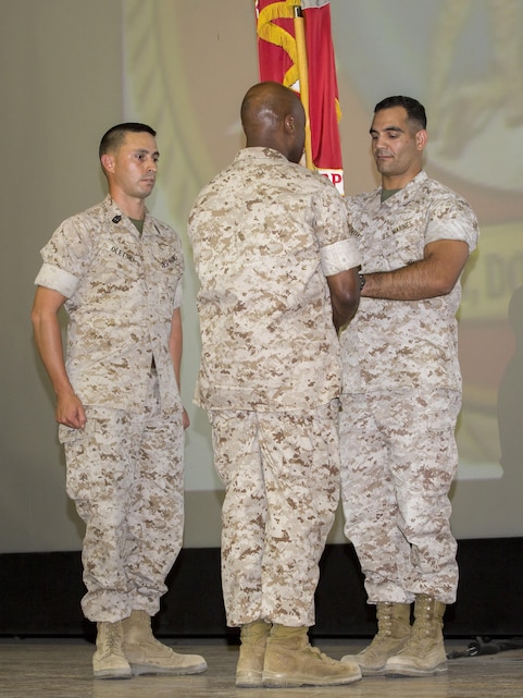 Lt. Col. Speros C. Koumparakis, outgoing commanding officer, passes the Communication Training Battalion’s colors to Lt. Col. Barian A. Woodward, oncoming commanding officer, during the battalion’s change of command ceremony at Sunset Cinema aboard the Marine Corps Air Ground Combat Center, Twentynine Palms, Calif., June 21, 2016. (Official Marine Corps photo by Lance Cpl. Levi Schultz/Released)