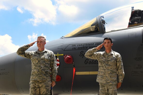 Staff Sgt. Adam Kipper (left) and Senior Airman Nicholas Landi (right), 4th Aircraft Maintenance Squadron dedicated crew chiefs, render salutes to Col. Christopher Sage, 4th Fighter Wing commander, after unveiling Sage’s name on the flagship F-15E Strike Eagle aircraft, June 30, 2016, at Seymour Johnson Air Force Base, North Carolina. Sage has supported operations NORTHERN WATCH, DELIBERATE FORGE, ALLIED FORCE, ENDURING FREEDOM and IRAQI FREEDOM and has logged more than 4,100 flight hours during his 22-year career. (U.S. Air Force photo/Airman 1st Class Ashley Williamson)