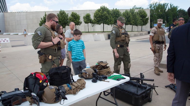 A Diplomatic Security Service federal agent talks to spectators about the gear and arsenal displayed during a demonstration at the National Museum of the Marine Corps in Triangle, Virginia, June 29, 2016. The DSS works alongside the Marine Corps Embassy Security Group to maintain and provide security for diplomats and foreign dignitaries at embassies.