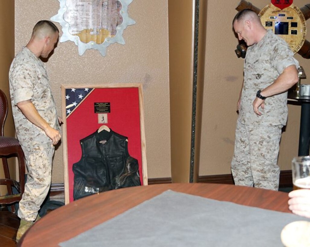 Both Col Eggers and LtCol Logan look over the plaque that LtCol Logan was presented at his retirement ceremony in honor of 24 years of faithful service