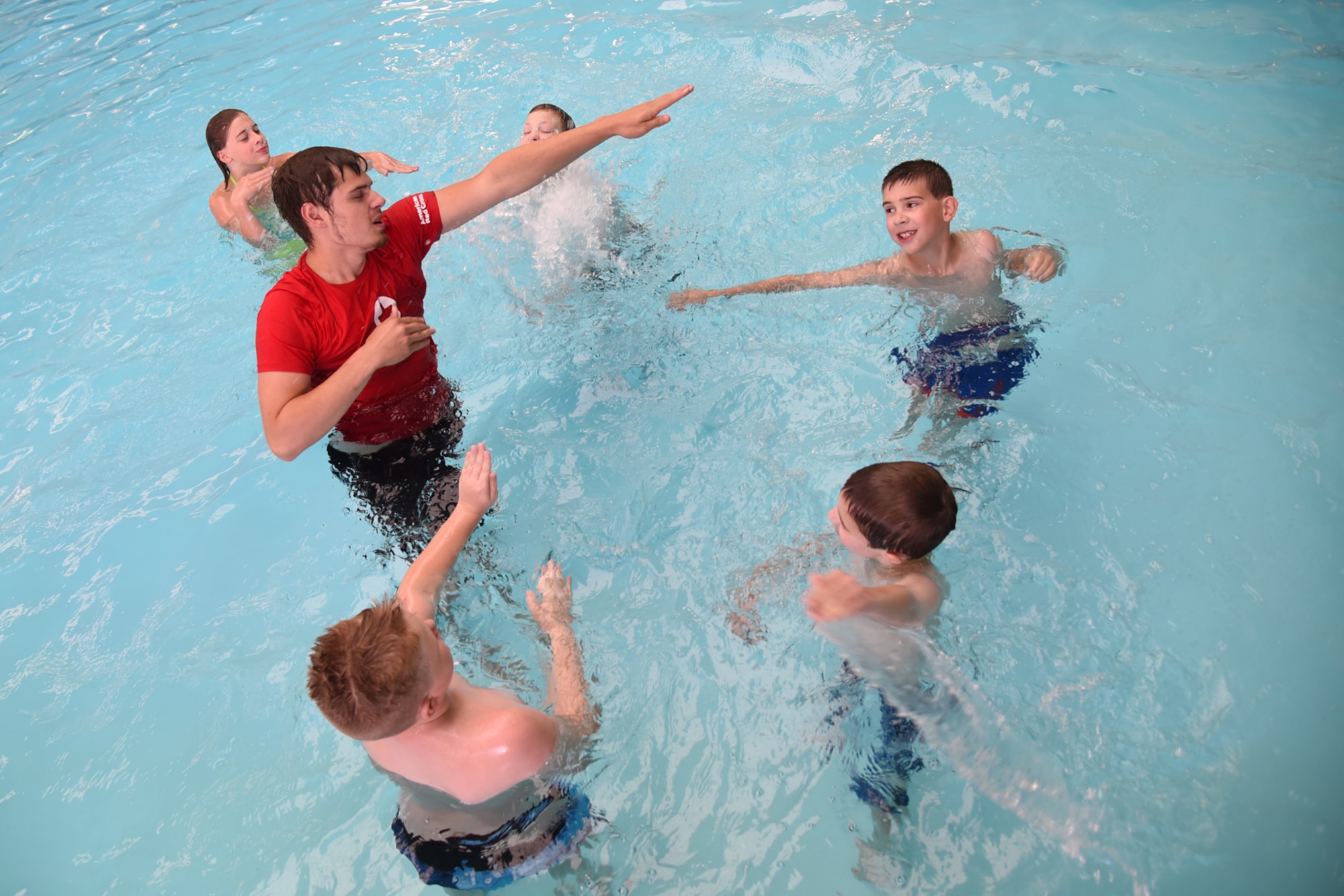 PETERSON AIR FORCE BASE, Colo. – Jacob Goulette, Peterson Aquatics Center lead lifeguard, explains how to position your arms while swimming during the World’s Largest Swimming Lesson at the Peterson Aquatics Center on Peterson Air Force Base, Colo., June 24, 2016. The World’s Largest Swimming Lesson is expecting more than 45,000 swimmers this year with the first lesson kicking off in Abu Dhabi and continuing through 24 countries in 24 hours. (U.S. Air Force photo by Airman 1st Class Dennis Hoffman)