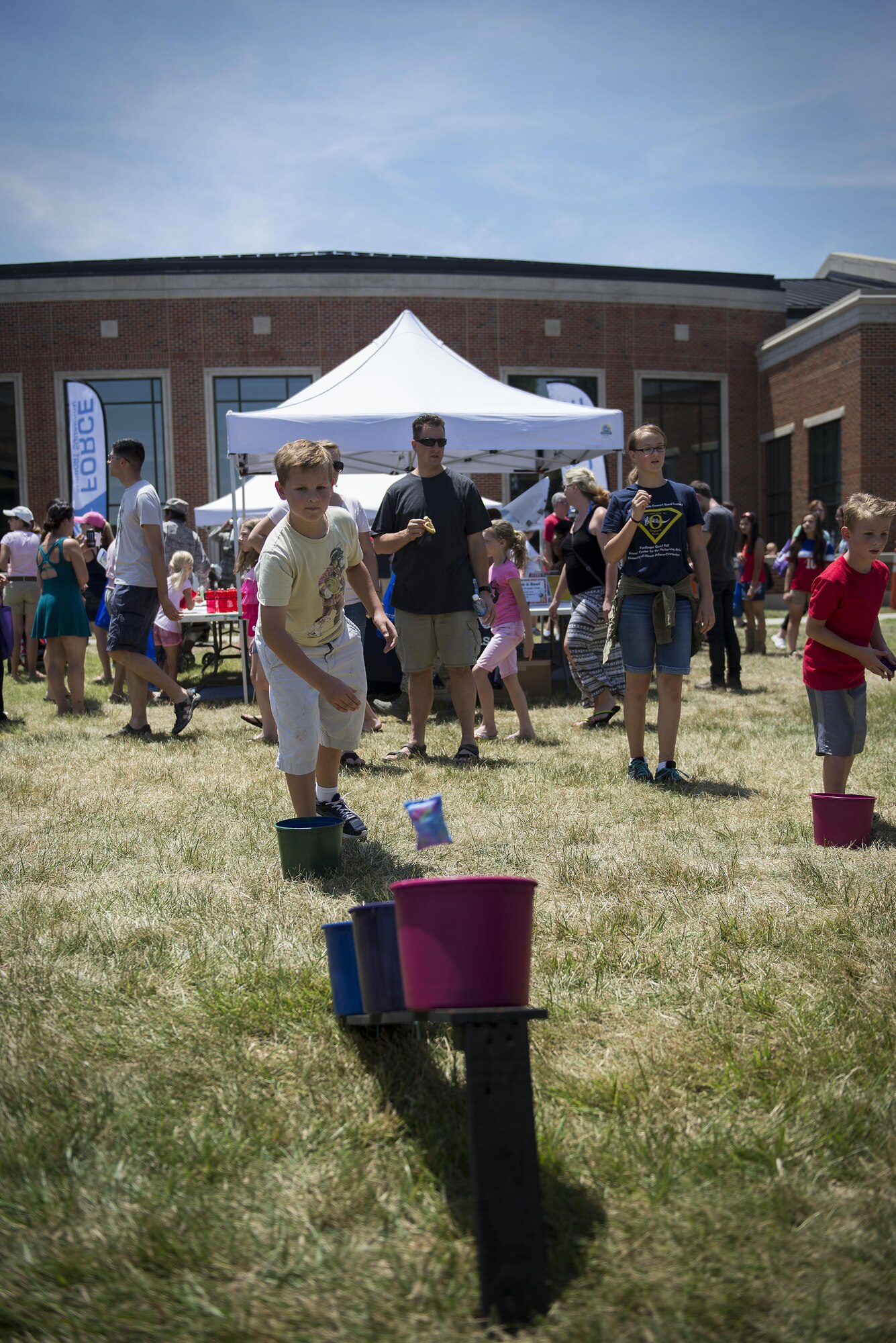 A Team Scott member attempts to throw a small sandbag into a bucket at an activity booth at the Scott Air Force Base Annual Base Picnic June 24, 2016. The base picnic was created to celebrate the base's and Air Force's diversity. (U.S. Air Force photo/Senior Airman Jake Eckhardt)