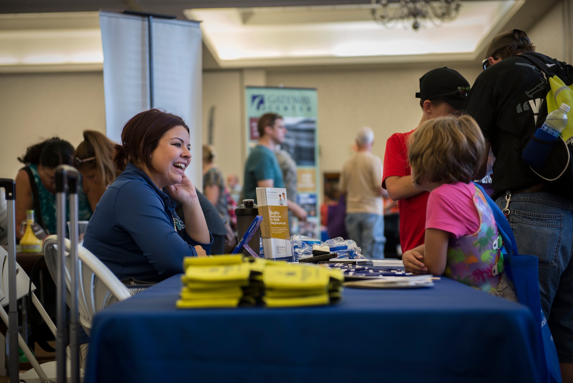 A Memorial Medical Group representative talks to a family about what the company offers at the Scott Air Force Base Annual Base Picnic June 24, 2016. The event had informational booths from local and national businesses, as well as games, activites and food for Team Scott to enjoy. (U.S. Air Force photo/Senior Airman Jake Eckhardt)