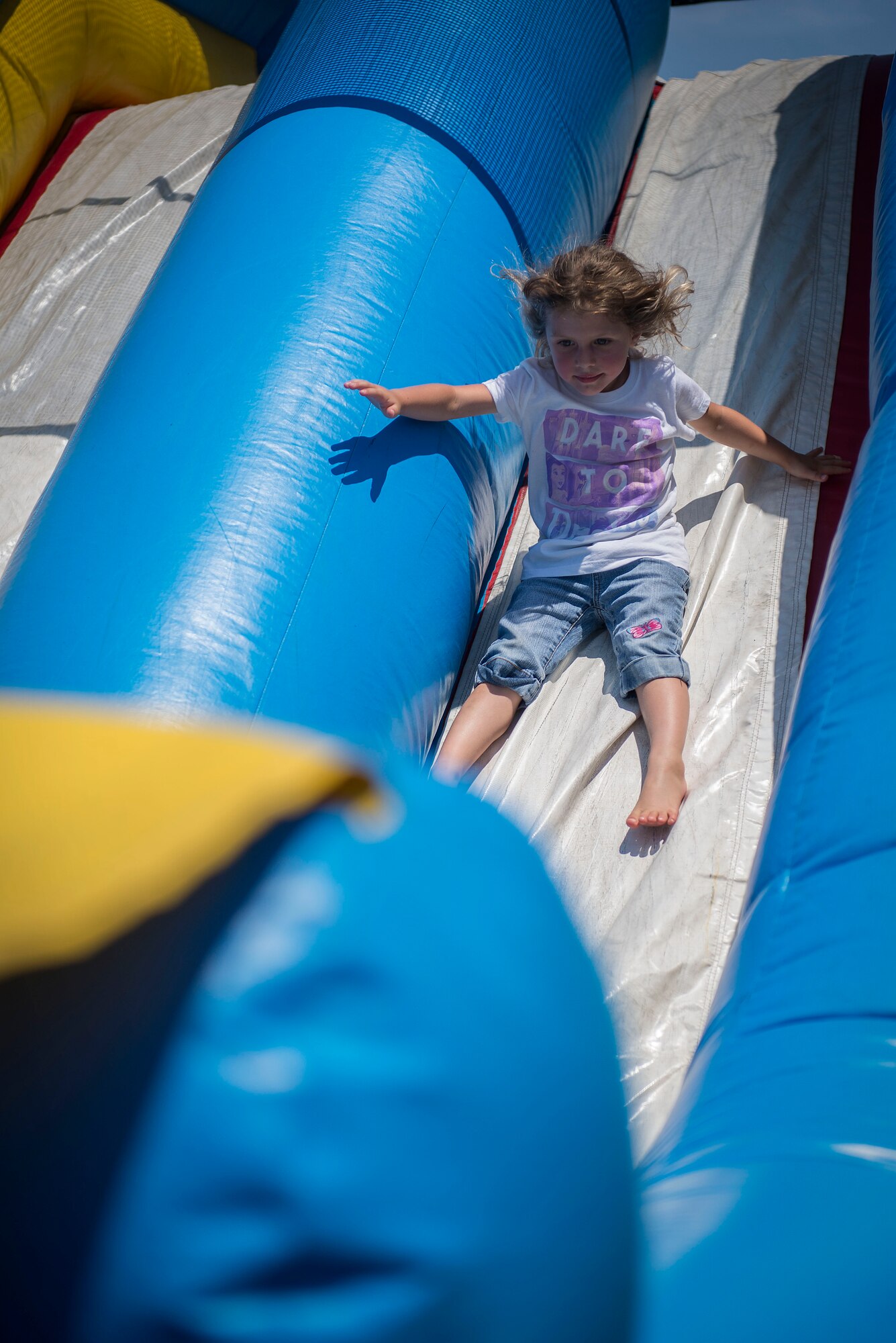 A child slides down an inflatable playhouse at the Scott Air Force Base Annual Base Picnic June 24, 2016. The event had informational booths from local and national businesses, as well as games, activites and food for Team Scott to enjoy. (U.S. Air Force photo/Senior Airman Jake Eckhardt)