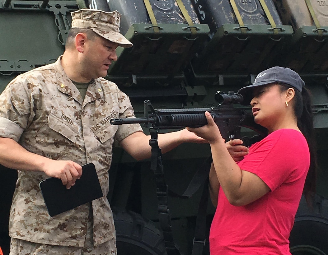 Maj. Christopher Smith, operations officer,  Headquarters and Service Battalion, provides instruction to his spouse, Jennifer Smith, on the use of the M-16 rifle before heading to the range for the live fire exercise during John/Jane Wayne Day June 24. Spouses of Marines had the opportunity to experience the Indoor Simulator Marksman Trainer (ISMT) and Virtual Combat Convoy Trainer (VCCT); live fire with the M249 SAW, M16A4 and M9 pistol; and a static display with Light Armored Vehicles (LAV) and weapons. Events like John/Jane Wayne Day provide an excellent opportunity for commands to improve their overall unit readiness by enhancing family readiness as it is vital to have the support of the families.