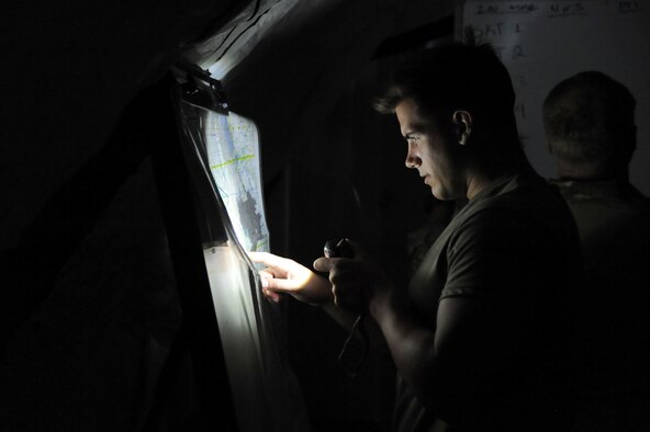 Airman 1st Class Alexander Kingsbury, 10th Air Support Operations Squadron joint terminal attack controller, reads a map inside an operation center, June 22, 2016, at Fort Riley, Kan. Tenth ASOS JTAC Airmen participated in a field training exercise to facilitate a combat mission ready posture within the squadron. (U.S. Air Force photo/Airman 1st Class Jenna K. Caldwell)