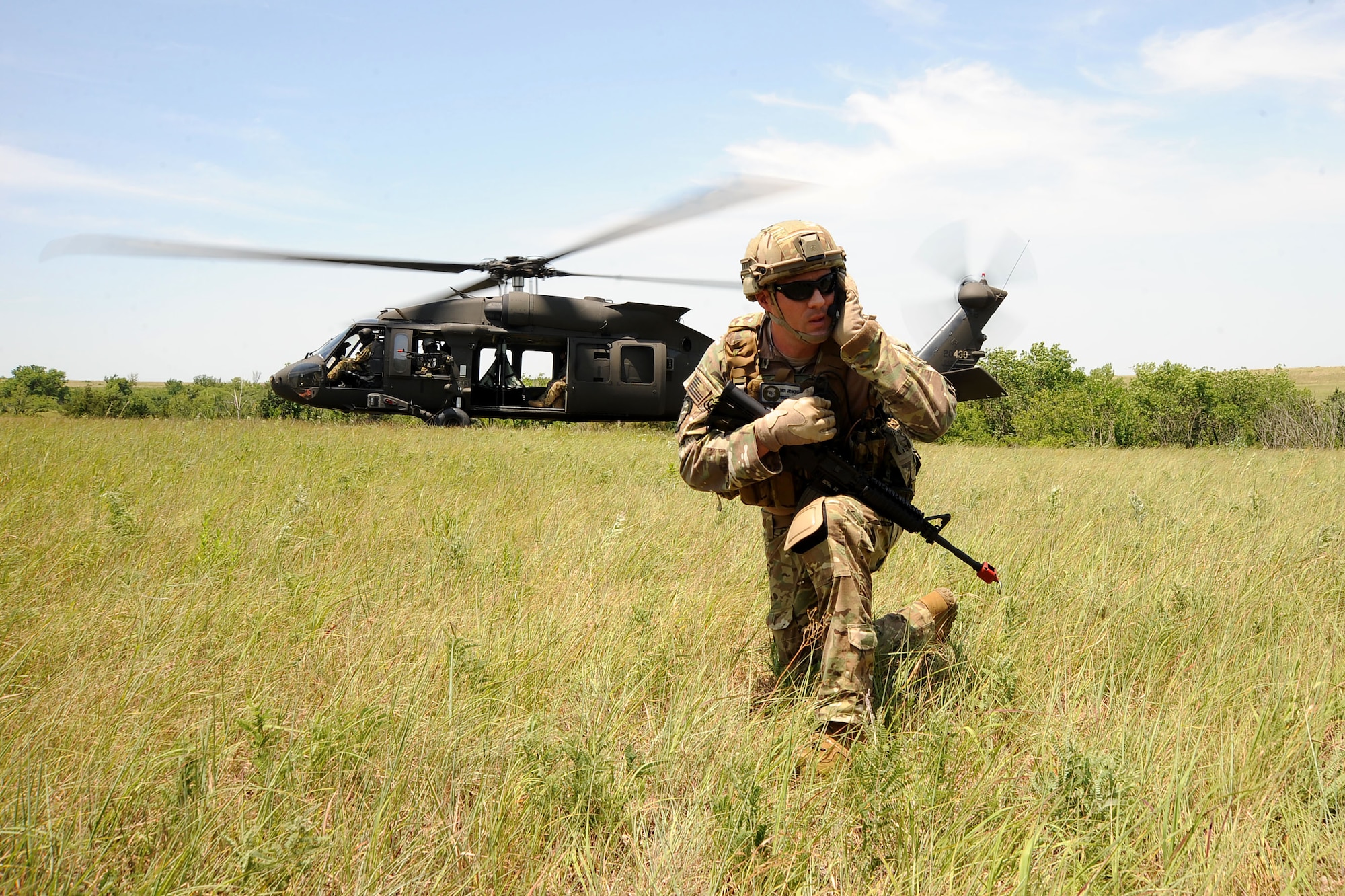 Master Sgt. Benjamin Jenkins, 10th Air Support Operations Squadron, chief joint terminal attack control instructor, communicates with aircrew in front of a UH-60 Blackhawk, June 22, 2016, at Fort Riley, Kan. JTACs provide Air Force support by planning and controlling combat air resources and operating communications in support of Army ground maneuver units. (U.S. Air Force photo/Airman 1st Class Jenna K. Caldwell)