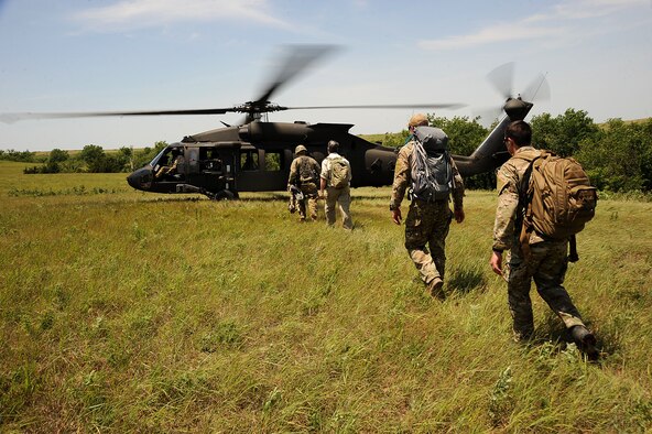 Tenth Air Support Operations Squadron joint terminal attack control Airmen escort aircrew to a UH-60 Blackhawk during a recovery exercise, June 22, 2016, at Fort Riley, Kan. JTAC Airmen, in support of a joint exercise with the Army, acted as pararescuemen for aircrew recovery operations. (U.S. Air Force photo/Airman 1st Class Jenna K. Caldwell)