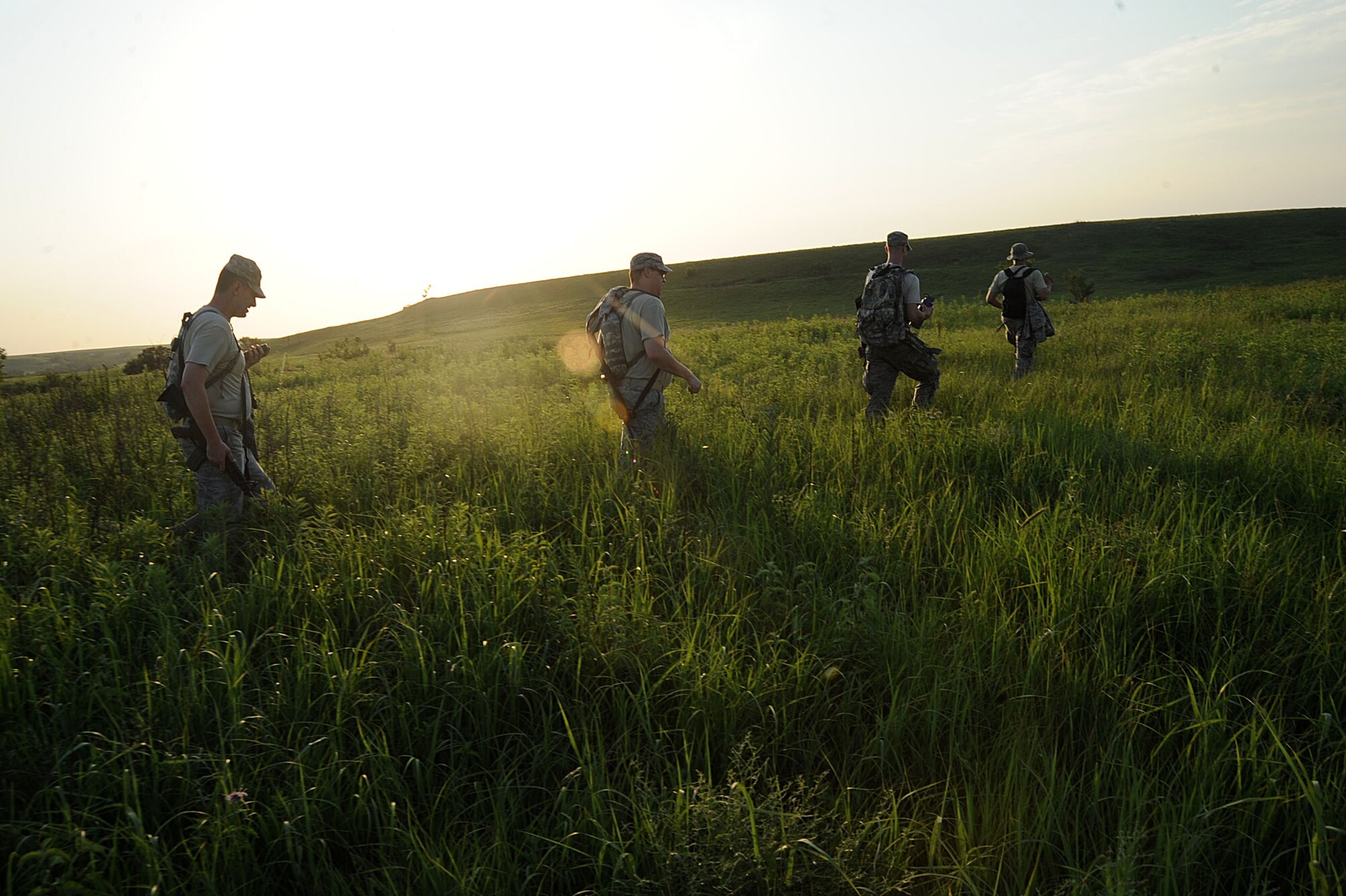 Tenth Air Support Operations Squadron joint terminal attack controllers march through a field during land navigation operations, June 22, 2016, at Fort Riley, Kan. Tenth ASOS JTAC Airmen participated in a field training exercise facilitated to ensure all Airmen are currently proficient, physically fit and mentally prepared to conduct full-spectrum close air support operations with unified combatant commands world-wide. (U.S. Air Force photo/Airman 1st Class Jenna K. Caldwell)
