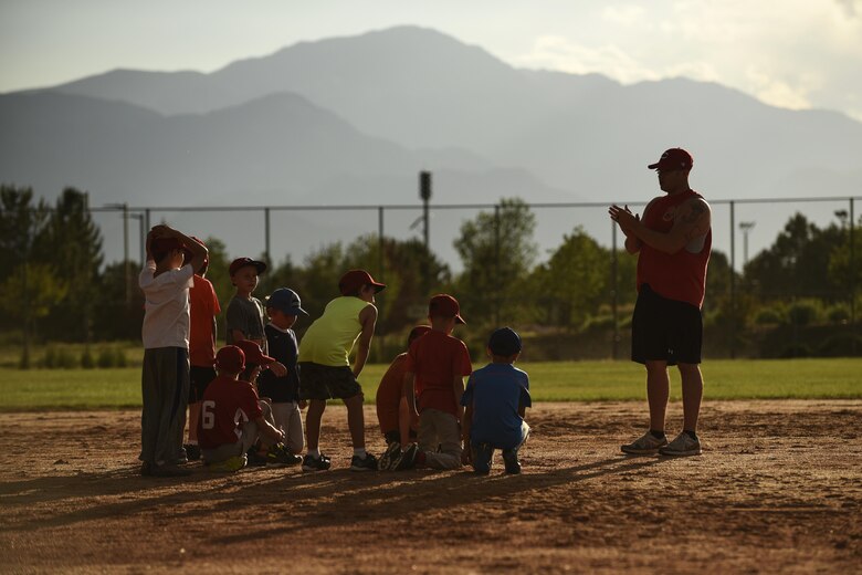 PETERSON AIR FORCE BASE, Colo. – The youth baseball team from the R.P. Lee Youth Center listen to their coach discuss how they did during practice here June 27, 2016. They were part of the youth sports program and learned different baseball skills at different stations on the field. (U.S. Air Force photo by Senior Airman Rose Gudex)