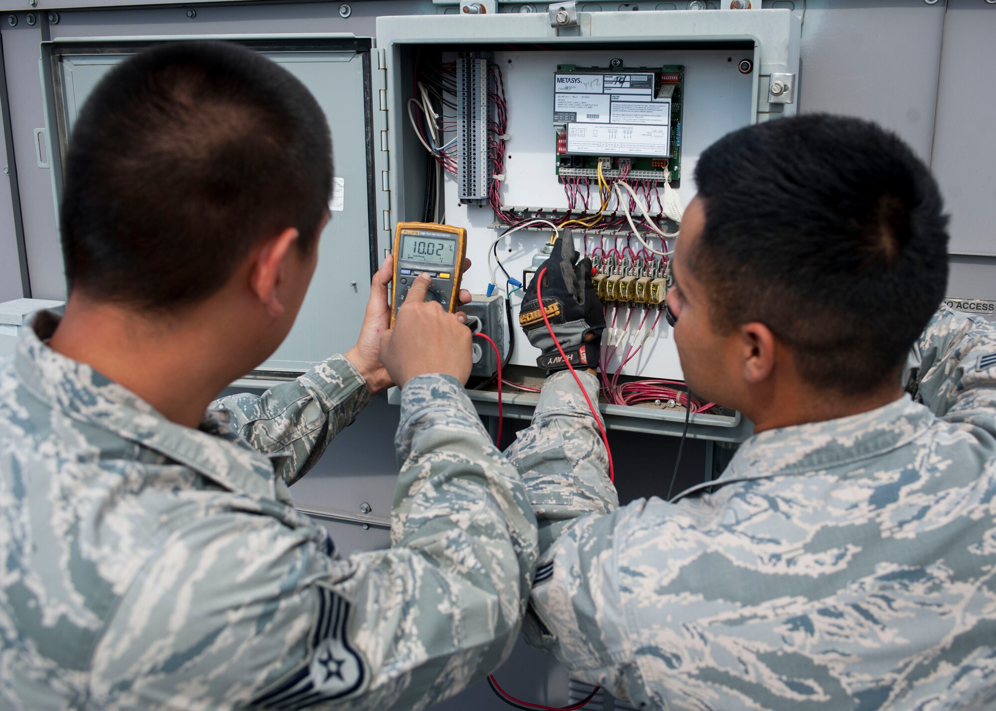 Staff Sgt. Dads Zyron Maniego, 99th Civil Engineer Squadron Heating, Ventilating, and Air Conditioning technician, and Senior Airman Octavio Nila 99th CES HVAC technician, check readings on an A/C unit atop of the Base Exchange on Nellis Air Force Base, Nev., June 28, 2016. With HVAC Controls only having a little over 30 Airmen able to support the base’s needs, customers may experience wait times when HVAC responds to emergency calls which can include the Base Exchange. 