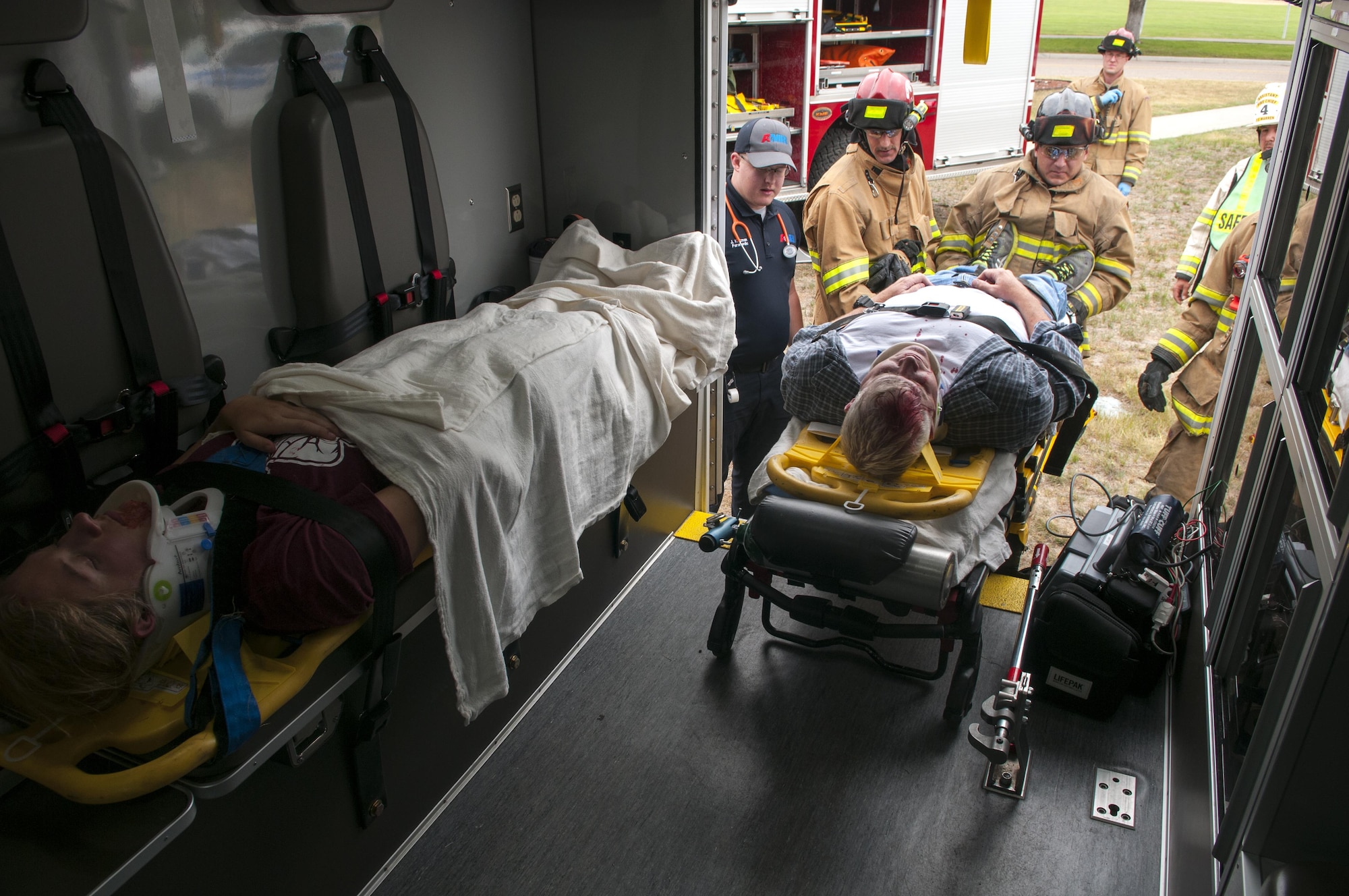 First responders secure Master Sgt. Josh Wilson, 90th Civil Engineering Squadron assistant fire chief, and Airman 1st Class Piper Whetstone, a 90th CES firefighter, inside of an ambulance during a drinking and driving awareness event at F.E. Warren Air Force Base, Wyo., June 30, 2016. The scenario involved multiple emergency response resources from security forces, firefighters and paramedics demonstrating what is done at the crash site. More than 200 Airman from the 90th Missile Wing attended the event to witness firsthand the devastating effects of a DUI. The DUI scenario concludes with personal speeches from those affected by the crash, the drunk driver, the spouse of the victim killed, and lastly with an obituary read by the base chaplain. (U.S. Air Force photo by Airman 1st Class Malcolm Mayfield)