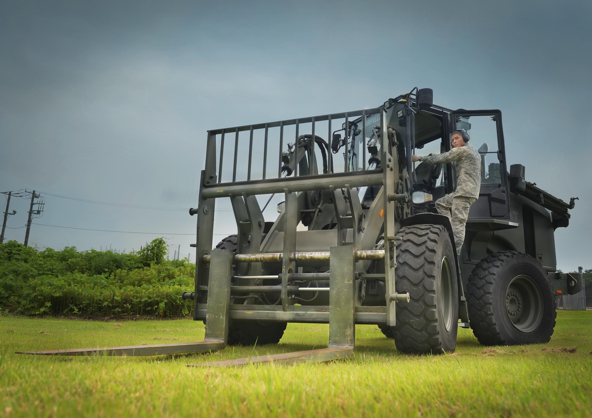 Airman Jalen Johnson 374th Logistics Readiness Squadron vehicle operator and dispatcher, poses for a photo with a 10k all-terrain forklift at Yokota Air Base, Japan, June 29, 2016. The 10k is essential to Yokota operations for its ability to lift, load and transport heavy cargo such as aircraft-part pallets. (U.S. Air Force illustration by Airman 1st Class Baker/Released)