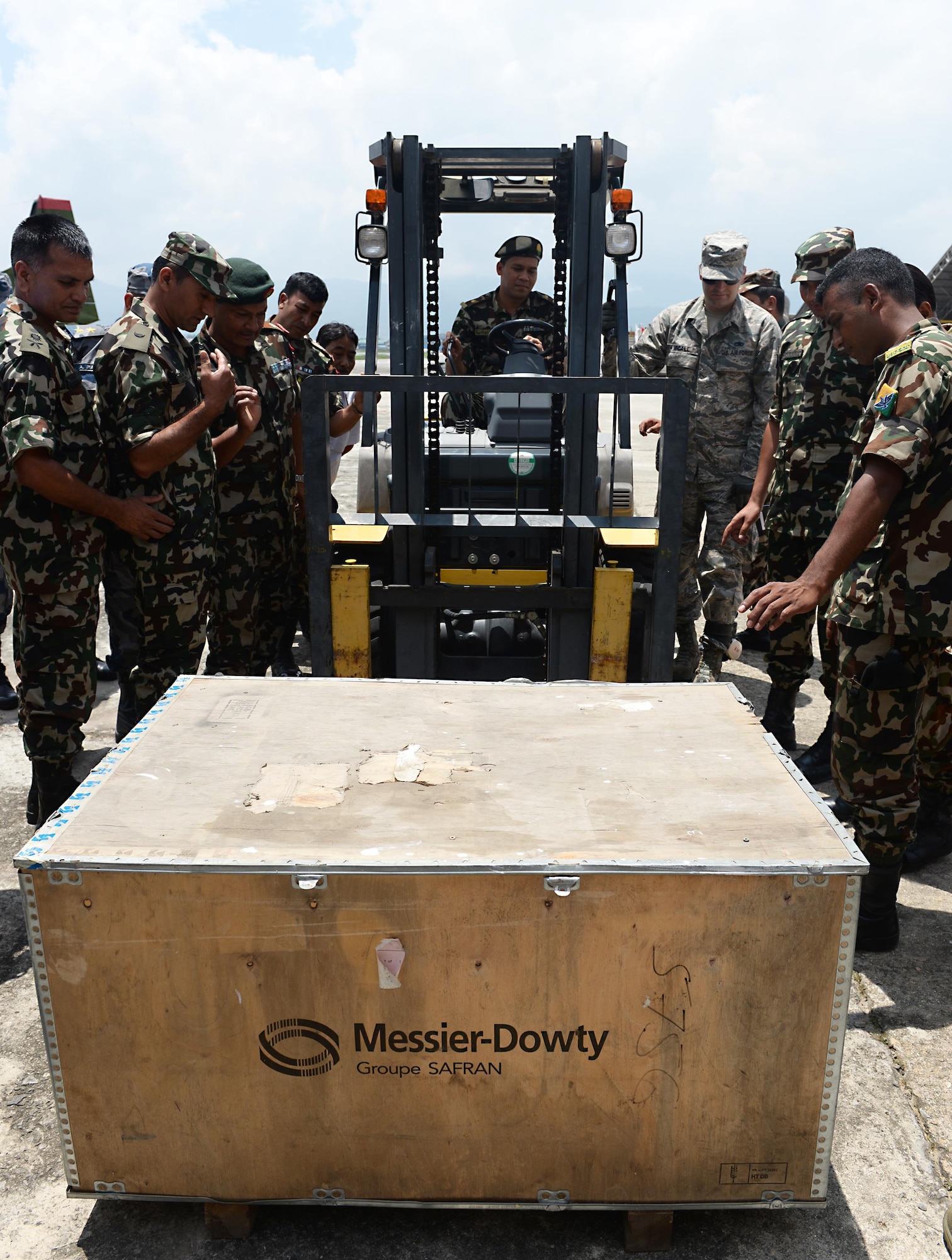 Tech. Sgt. Derrick McCall, 36th Contingency Response Group, demonstrates how to lift an object as a member of the Nepalese Army operates a forklift June 28, 2016, at Tribhuvan International Airport in Kathmandu, Nepal. Ten Airmen from the 36th CRG and more than 20 service members from various Nepalese organizations participated in a subject-matter expert exchange where participants familiarized themselves with operating a forklift and learned techniques on transporting cargo. (U.S. Air Force photo by Staff Sgt. Benjamin Gonsier/Released)