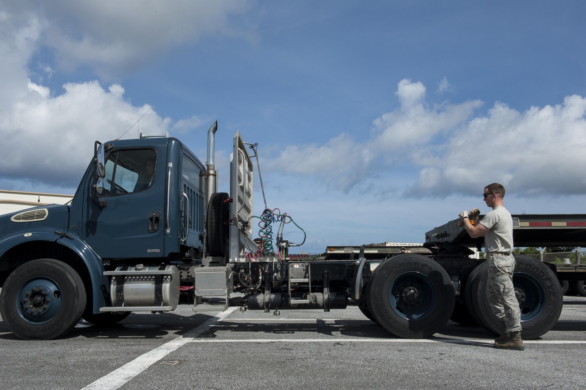 U.S. Air Force Staff Sgt. Aaron Paecht, 18th Logistics Readiness Squadron NCO in charge of training, validation and operations, guides Airman 1st Class Marcus Denton, 18th LRS vehicle operator, as he uncouples the trailer of a tractor-trailer June 29, 2016, at Kadena Air Base, Japan. The 18th LRS conducted tractor-trailer training assisting members in carrying out their missions across the 18th Wing. (U.S. Air Force photo by Airman 1st Class Lynette M. Rolen)