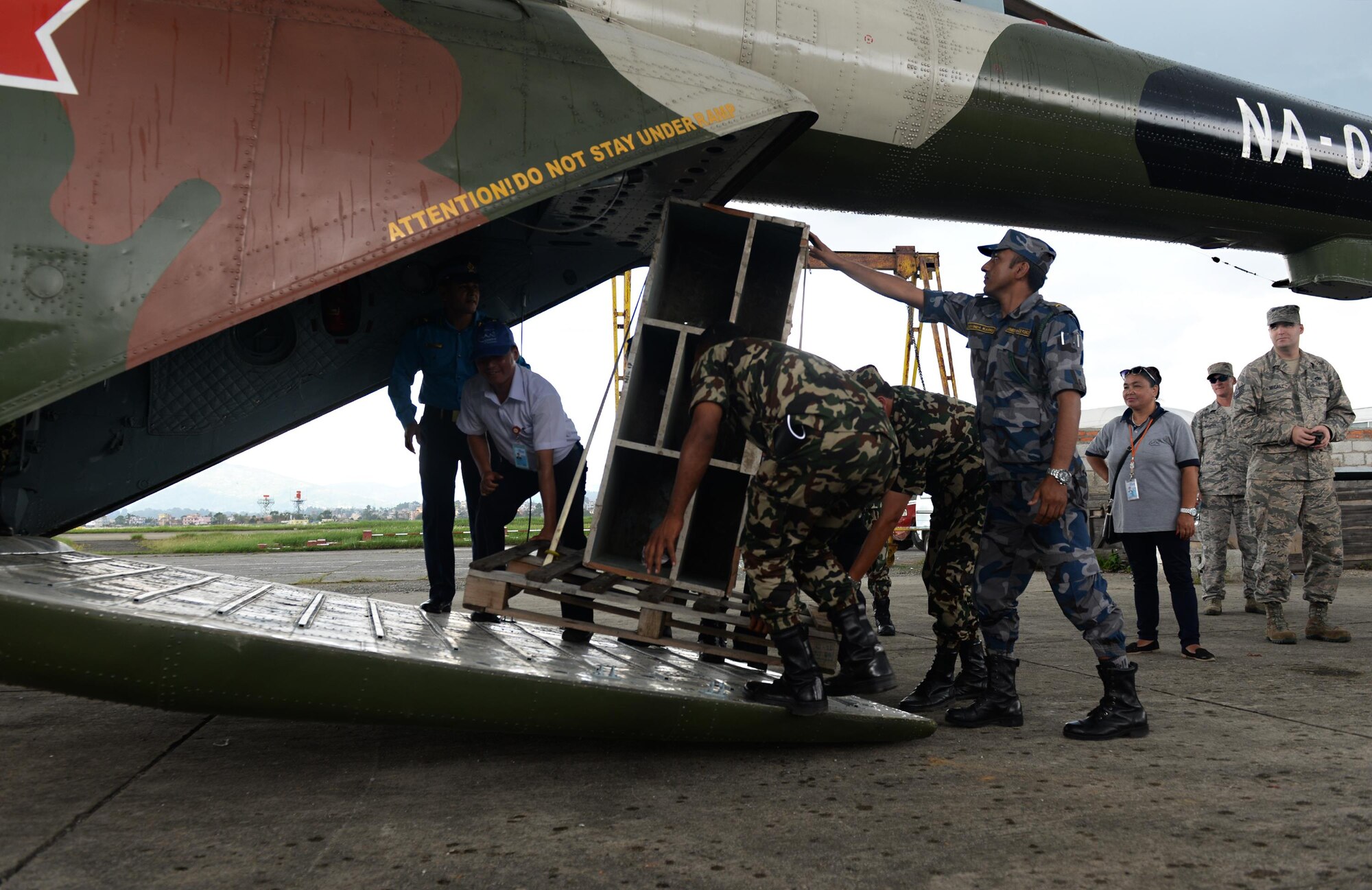 Participants of a subject-matter expert exchange load an irregularly sized object onto an MI-17V-5 Helicopter June 29, 2016, at Tribhuvan International Airport in Kathmandu, Nepal. During the SMEE, participants exchanged knowledge on forklift operation and loading procedures for aircraft cargo of varying dimensions. (U.S. Air Force photo by Staff Sgt. Benjamin Gonsier/Released)