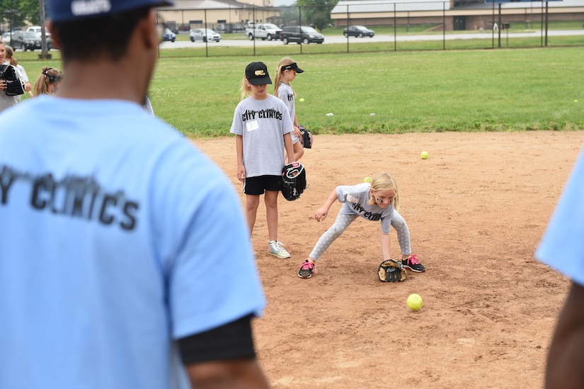 Collegiate baseball players teach children of military personnel how to catch ground balls at the Major League Baseball Players Trust City Clinic’s youth baseball clinic on Joint Base Andrews, Md., June 28, 2016. The Players Trust, DC Grays, a Cal Ripken Collegiate Baseball League team, and USO Metro coordinated this event. More than 100 children attended the clinic, receiving coaching from collegiate and professional baseball players, as well as free baseballs, gloves, T-shirts and autograph cards. (U.S. Air Force photo by Senior Airman Joshua R. M. Dewberry)