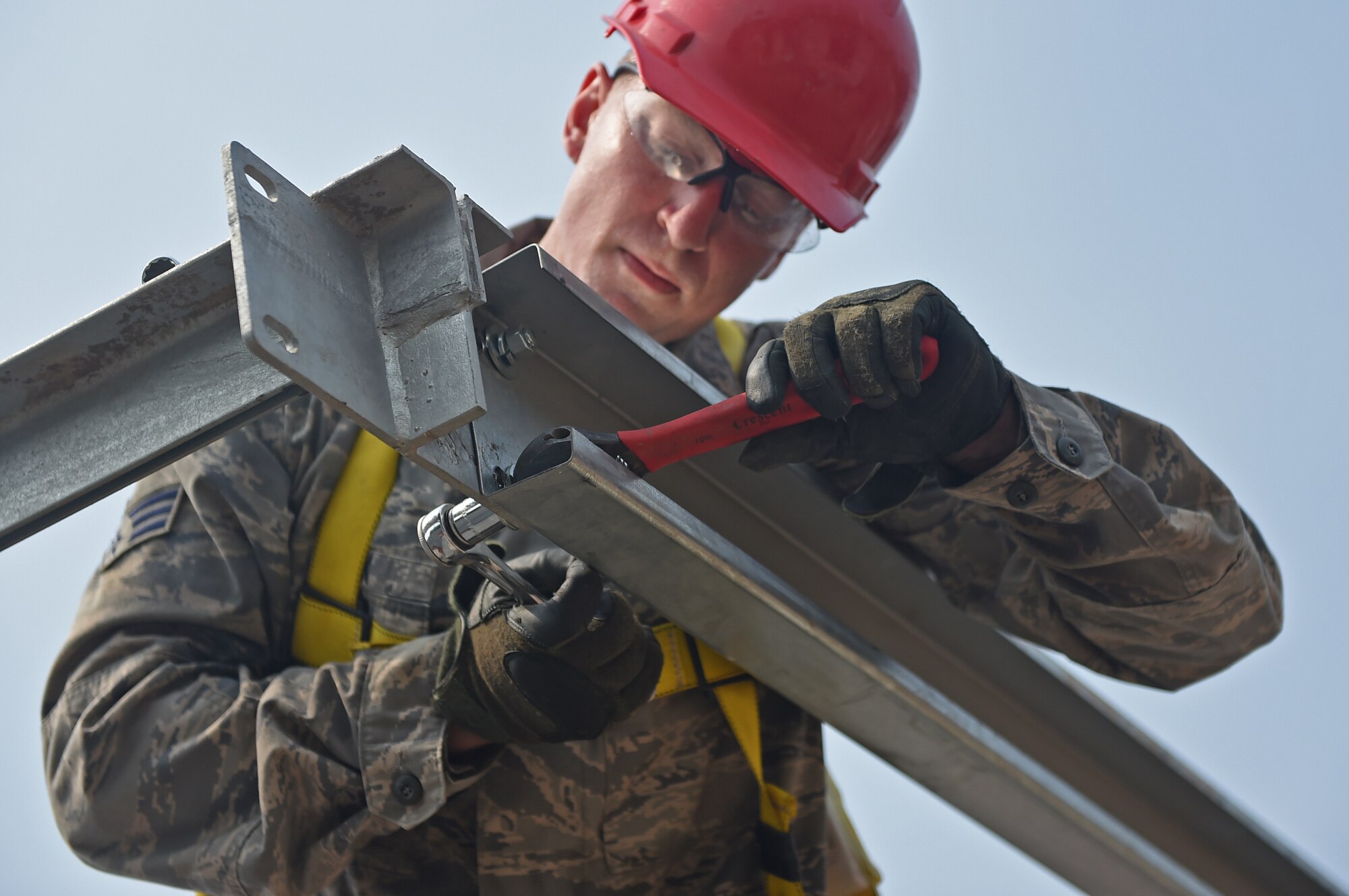 Pennsylvania Air National Guard Senior Airman Daniel Clark, 201st Rapid Engineer Deployable Heavy Operational Repair Squadron Engineers structures technician, tightens a bolt on a purlin beam as part of the construction process for a new medical clinic May 3, 2016 during Exercise BEYOND THE HORIZON 2016 GUATEMALA. The bolts that secure the purlin beam to the trusses are tightened using locking washers to keep them from loosening under stress. (U.S. Air Force photo by Senior Airman Dillon Davis)