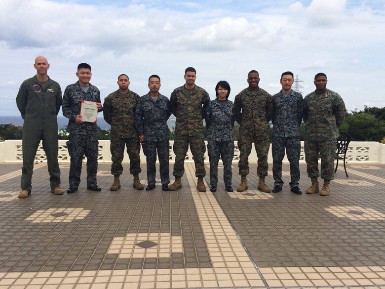 Members of the Japanese Air Self Defense Force pose with U.S. Marines for a photo at a farewell luncheon for the professional military exchange program February 23 at the Habu Pit Officers’ Club on Marine Corps Air Station Futenma, The professional military exchange program benefits JASDF and Marines by providing first-hand insight to the daily routines and responsibilities of each service, according to Staff Sgt. Shinya Nishida, second from left. The experience and knowledge gained through the program establishes better understanding and communication. After Nishida’s exposure to the Marine Corps, the JASDF will return the favor by taking in a Marine in March to experience day-to-day routines of the JASDF. Nishida was a participant of the program and is a flight plan dispatcher with the JASDF. (U.S. Marine Corps Photo by Cpl. Brittany A. James/Released)