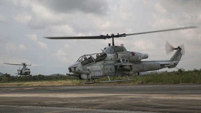 A AH-1 Cobra (Right) and a UH-1Y Huey prepare to touch down at a refuel point before a flight mission during Exercise Cobra Gold 16 in Utapao, Thailand, Feb. 16, 2016. The Huey and Cobra usually fly together to increase mission capabilities. The Huey brings capable sensors and the Cobra brings long distance weapon systems resulting in a reliable escort team. The Marines are with Marine Light Attack Helicopter Squadron 167, currently supporting Marine Aircraft Group 36, 1stl Marine Aircraft Wing, III Marine Expeditionary Force as part of the unit deployment program.