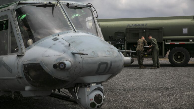 Two Marines work together to refuel a UH-1Y Huey before a flight during Exercise Cobra Gold in Utapao, Thailand, Feb. 16, 2016. Logistic and aviation units work together to practice the characteristics of a Marine Air-Ground Task Force. Cobra Gold is a multi-national exercise designed to build partnership and interoperability between participating nations. The Marines are with Marine Wing Support Squadron 172, Marine Aircraft Group 36. 1st Marine Aircraft Wing, III Marine Expeditionary Force. 
