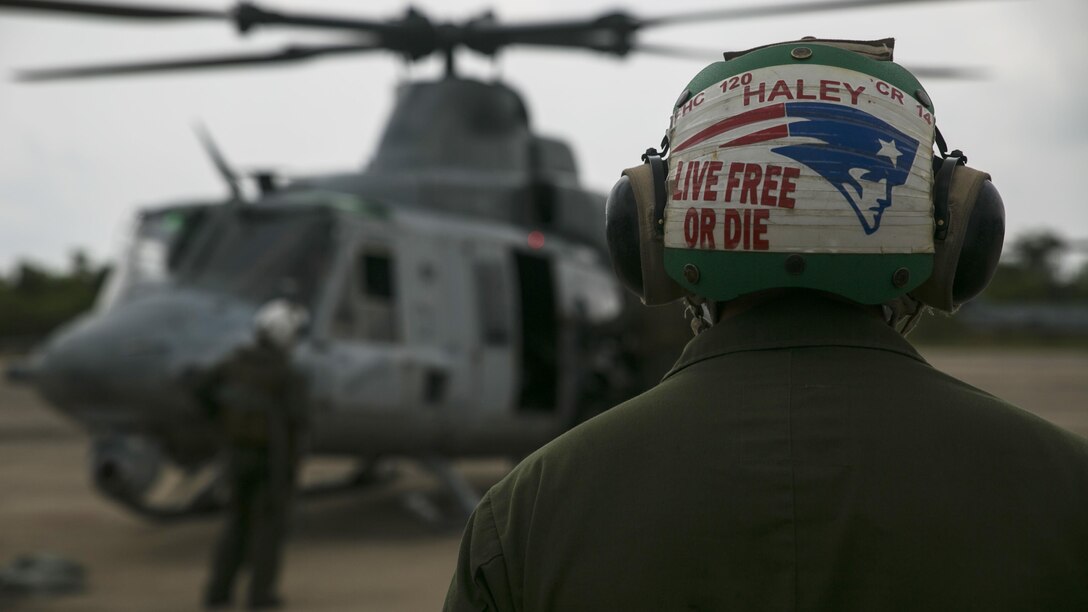 Sgt. Andrew A. Haley observes a UH-1Y Huey as it prepares to take off for a flight mission during Exercise Cobra Gold 16 in Utapao, Thailand, February 16, 2016. Haley, an avid New England Patriots fan, is one of many maintainers who help prepare aircraft before and after takeoff. Cobra Gold is a multi-national exercise designed to advance regional security and ensure effective responses to regional crises by bringing together a robust combined task force from partner nations sharing common goals. Haley, from Conway, New Hampshire, is an airframe mechanic with Marine Light Attack Helicopter Squadron 167, currently supporting Marine Aircraft Group 36, 1st Marine Aircraft Wing, III Marine Expeditionary Force as part of the unit deployment program.