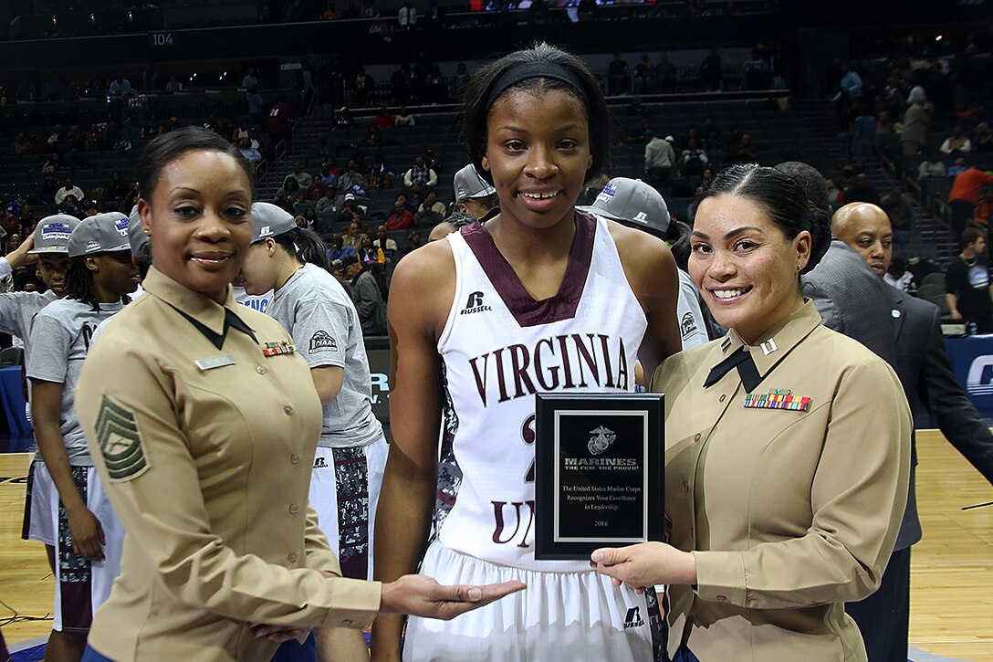 Master Sgt. Amy Romero, Marine reservist, and Capt. Evita Mosqueda-Chapman, logistics officer for 4th Tank Battalion, hand the Marine Corps Excellence in Leadership Award to Lady Walker of Virginia Union University following the women’s finals game of the CIAA championships at the Time Warner Cable Arena in Charlotte, N.C., Feb. 27, 2016. Virginia Union University defeated Shaw University 70 - 66. The Marines are present at the Central Intercollegiate Athletic Association championships to spread awareness to student athletes and fans about opportunities in the Marine Corps. (Official Marine Corps photo by Cpl. John-Paul Imbody)