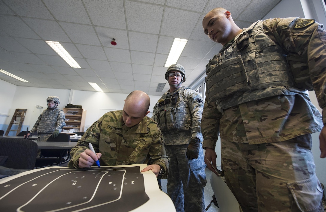 Army Sgt. Charles Porter counts his hits on a target after qualifying with a 9 mm pistol at a military shooting range in Landstuhl, Germany, Feb. 25, 2016. Porter and other soldiers wore advanced combat helmets and other personal protective equipment during the training to protect themselves from possible injuries, such as traumatic brain injuries. DoD photo by Air Force Tech. Sgt. Brian Kimball